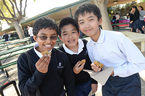 Smiling Harker students eating cookies on Howard Nichols Cookie Day