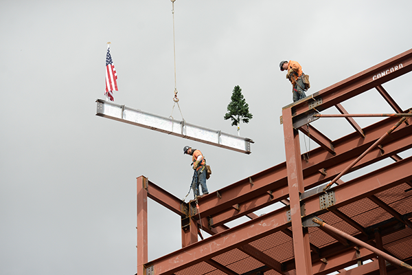 Beam being lifted to top of building